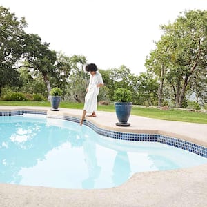 Woman dipping toes in backyard pool