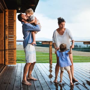 Family plays in rain on wood deck