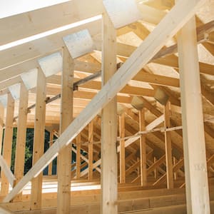 Man builds the wooden roof of a barn