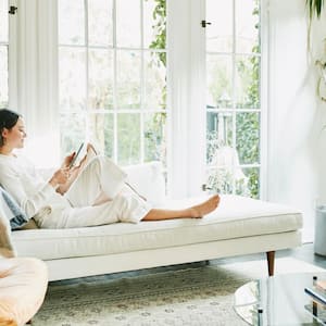 A woman relaxing on sofa in a bright living room