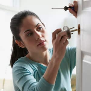 A woman replaces door knob