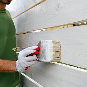 Man painting fence