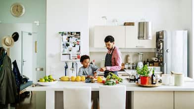 Son helping father cooking a meal