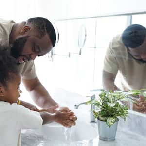  A father helping his daughter to wash her hands