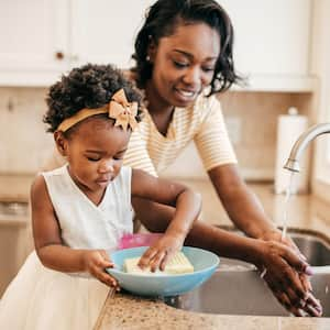 Mom and toddler wash dishes