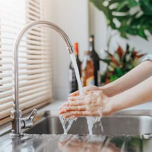 Woman washing hands in kitchen sink