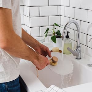 Man washing dishes with a brush