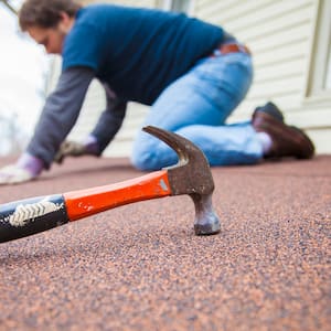 man on roof with hammer