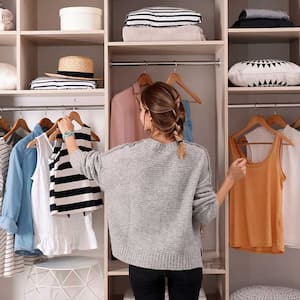 Woman choosing a sleeveless top from her closet