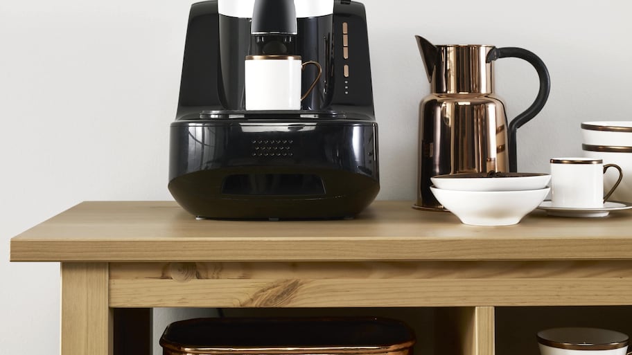 Coffee maker and mugs on wooden shelf