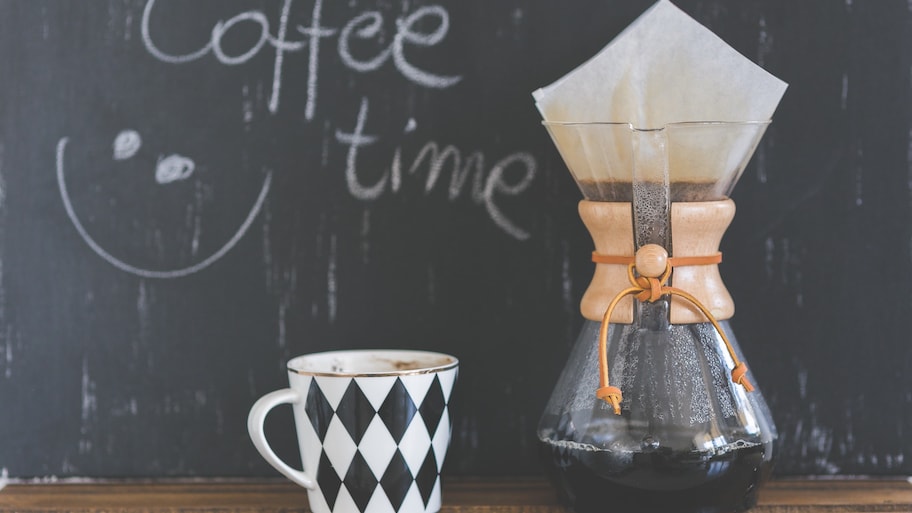 Coffee mug and coffee maker with chalkboard background