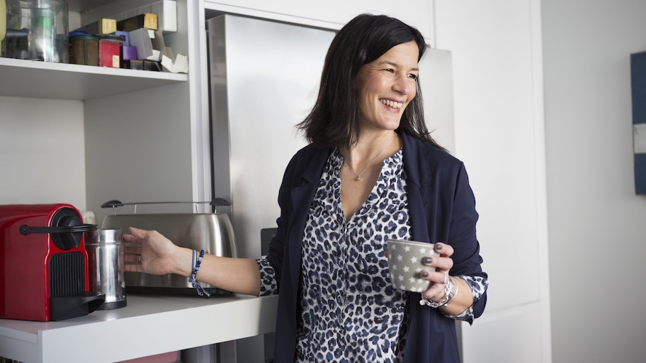 Woman using coffee machine on pull-out shelf