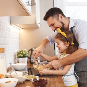 father and daughter cooking in kitchen