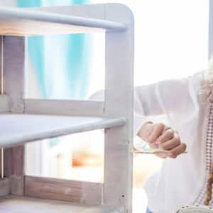 Woman painting cabinet white with chalk paint