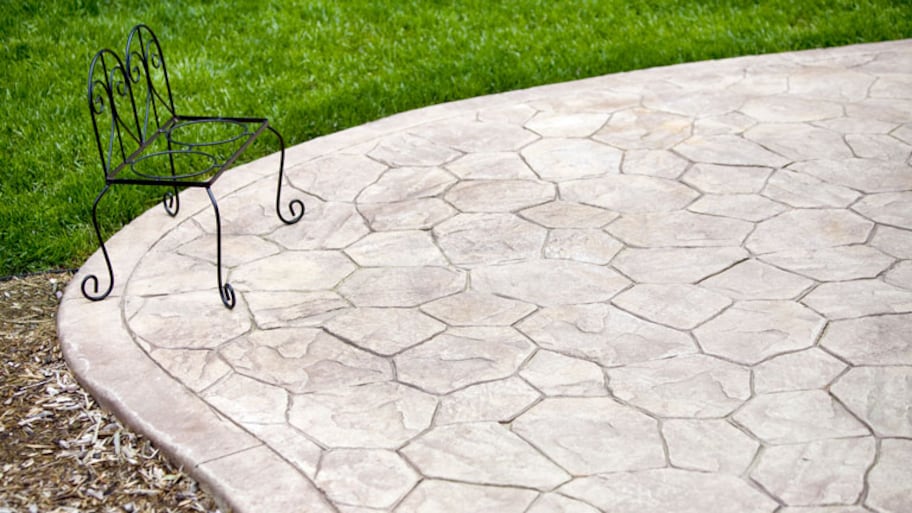 concrete backyard patio with small black outdoor chair