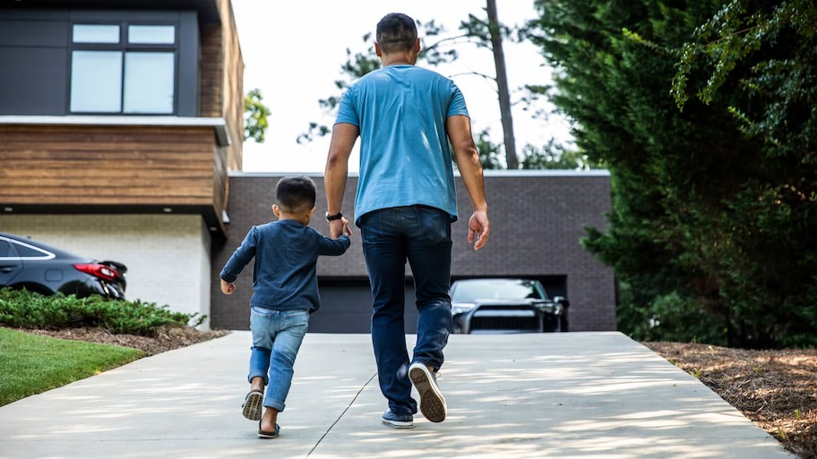 A father and his son walking up a driveway