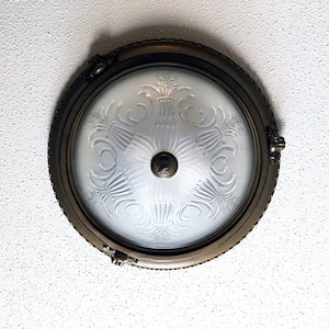 Round mounted ceiling light fixture on a popcorn ceiling