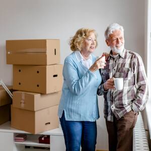 Senior couple at moving day looking through the window