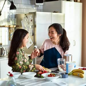 Mother and daughter making smoothies