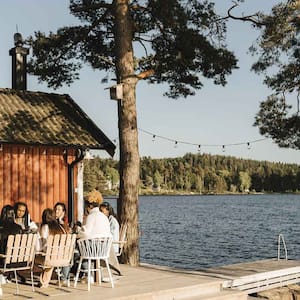 Group of friends having dinner by the lake