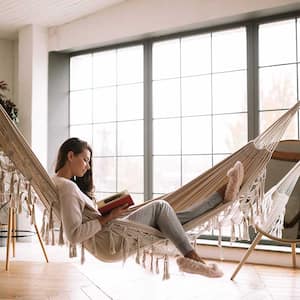 Woman lying in a hammock reading a book