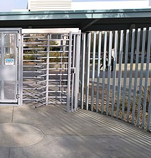 full height turnstile integrated into a fence line at building entrance