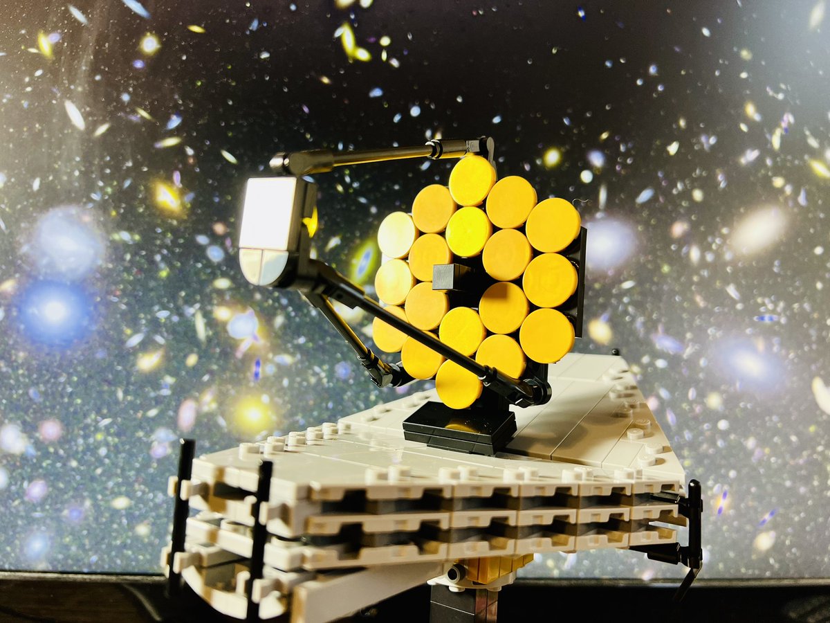 Lego mod of the James Webb Space Telescope in front of a background of galaxies.