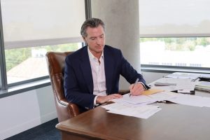 Governor Newsom signs bill at his desk