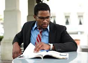 man reading a magazine while sitting at a table