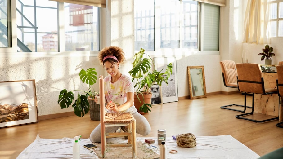 A woman painting chair at home