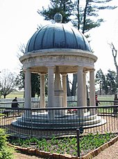 A tomb in a garden covered by a circular roof