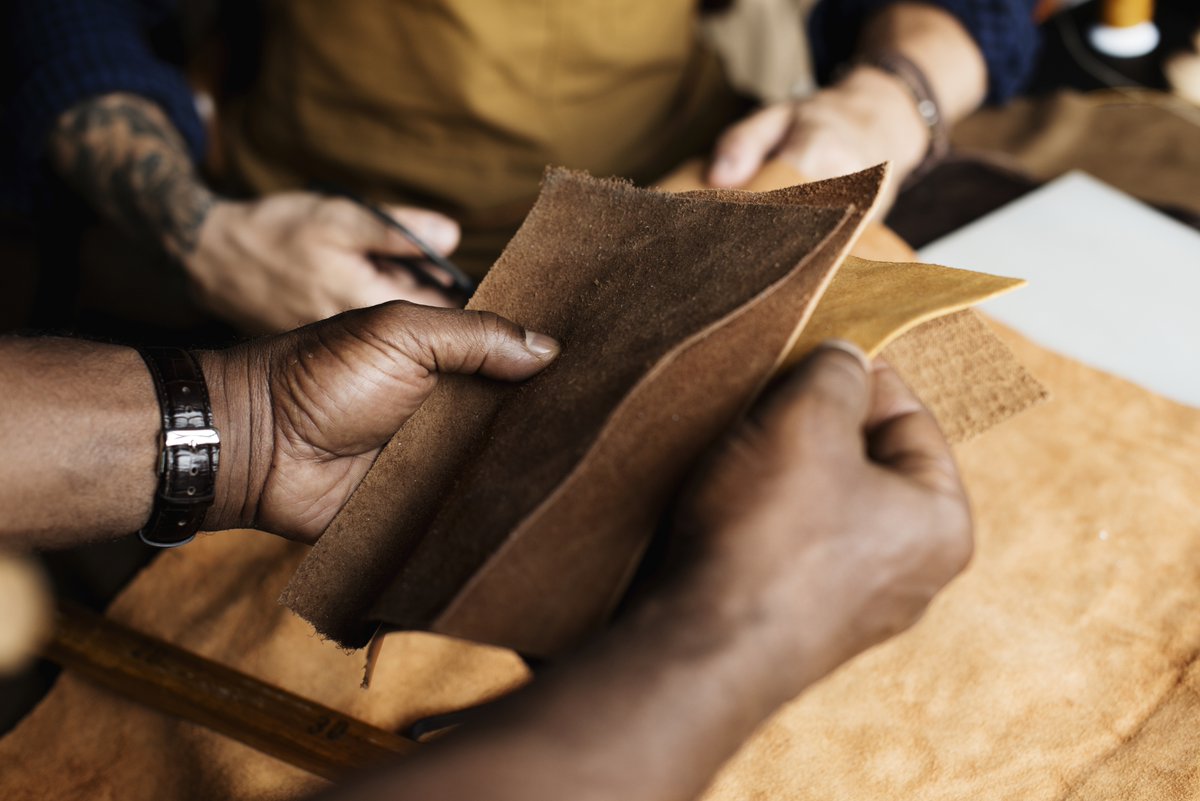 Artisanal craftsmen working with a leather-like material