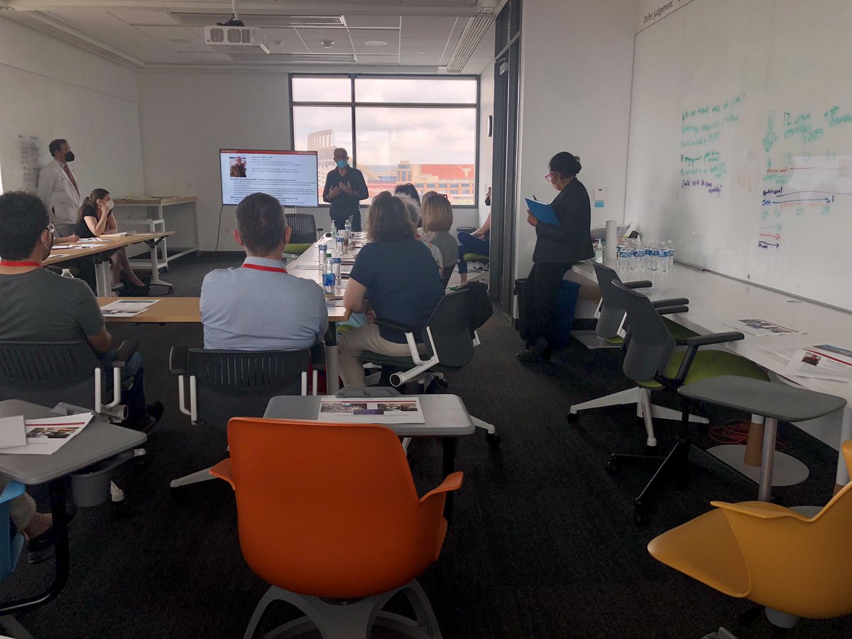 Researchers present to a room of professionally dressed health care journalists.