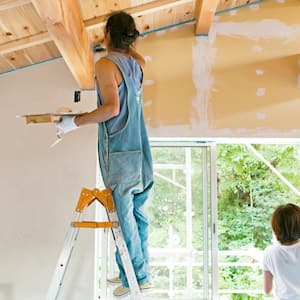 A couple plastering a wall 