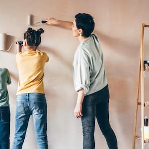 mom and two kids painting wall 