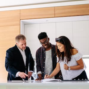 Realtor and couple signing mortgage contract