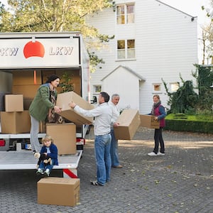 family loading boxes onto moving truck 