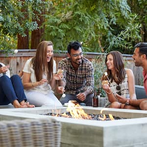 friends hanging out by large outdoor fire pit 