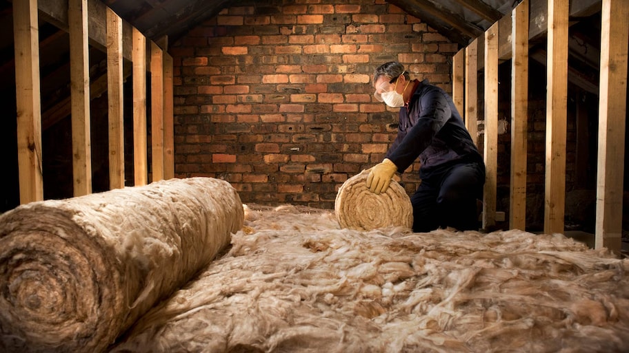 A professional installing insulation in an attic