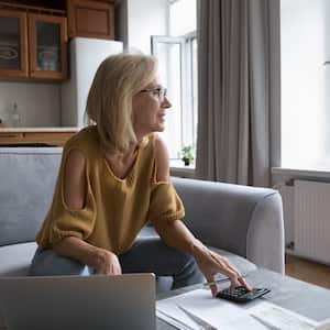 A woman thinking over monthly paperwork