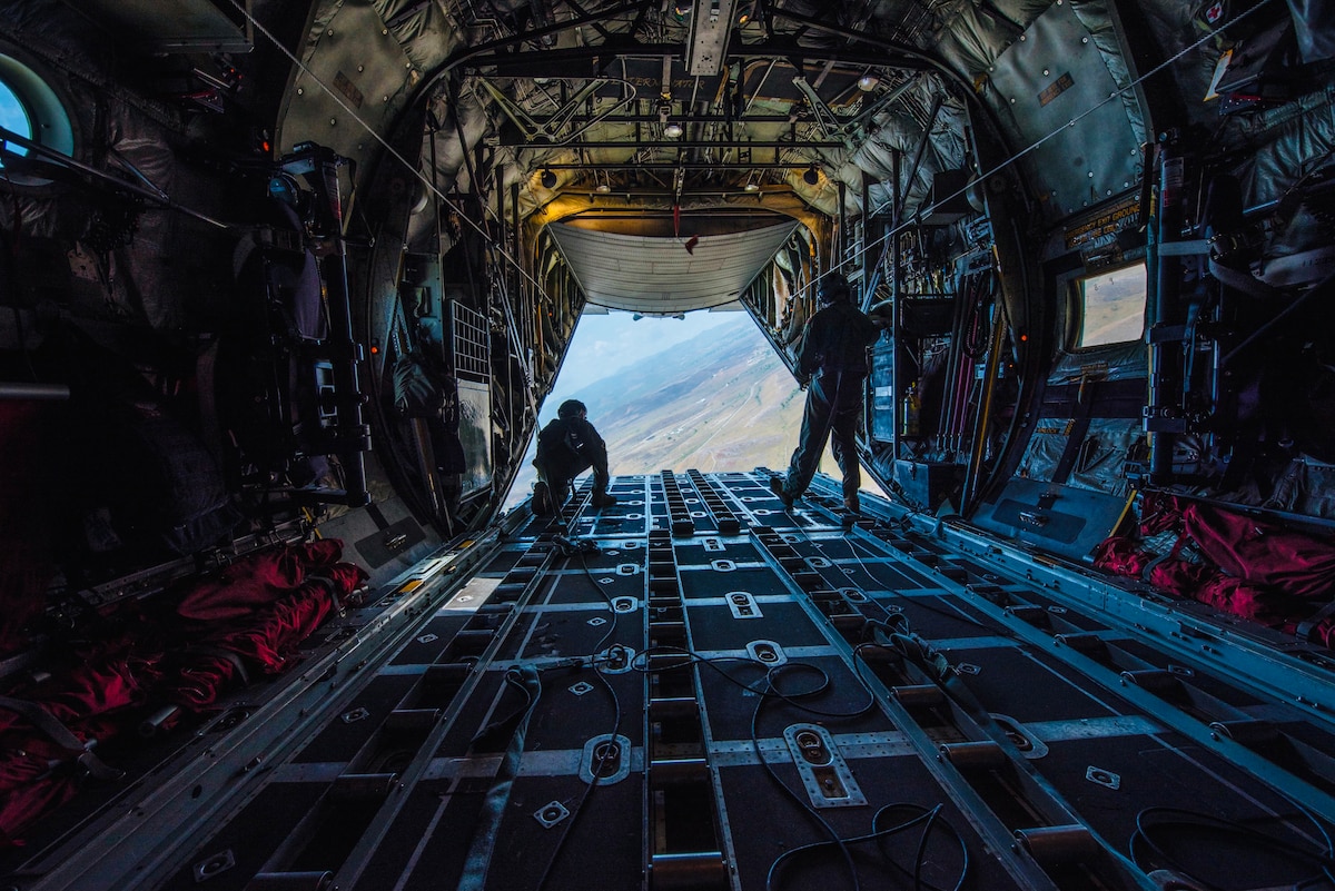 Senior Airman Eric Burk (left) and Master Sgt. Judson Wisely, loadmasters from the Kentucky Air National Guard’s 123rd Operations Group, simulate an airdrop June 14, 2021, over mountain terrain in Puerto Rico as part of Maintenance University. Kentucky aircrews also re-certified on low-level tactical maneuvers and open-ocean flying during the week-long event. (U.S. Air National Guard photo by Staff Sgt. Clayton Wear)