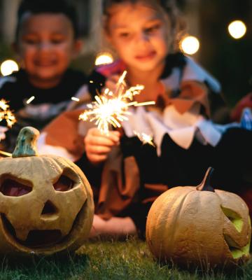 Kids with fireworks and Halloween carved pumpkins