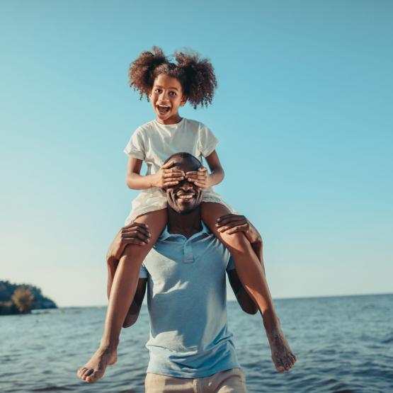 A father and daughter hang out on the beach together