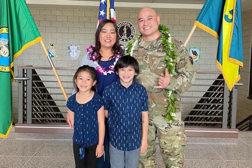 A service member and his family pose for a photo.