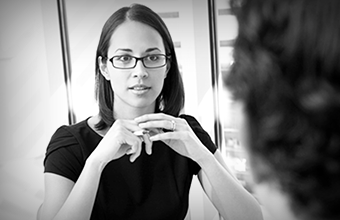 Woman in glasses holding a pen