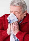 a woman blowing her nose outside in the cold