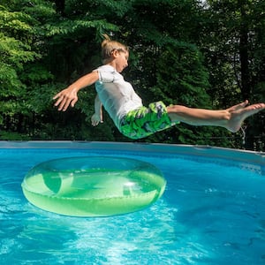 Boy jumping in an above ground pool