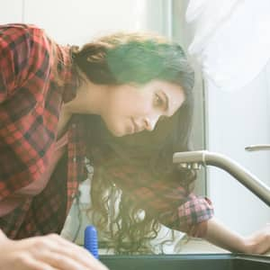 A woman checking a faucet