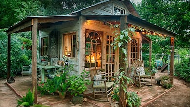 elaborate rustic she-shed with windows, landscaping, roof and lighting