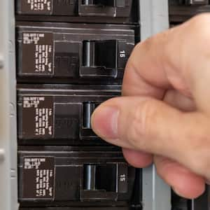 Man turning switch on circuit breaker